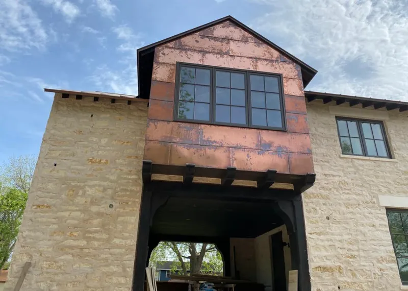 Copper metal panel facade on a stone building for Roof Repair in East Lake-Orient Park