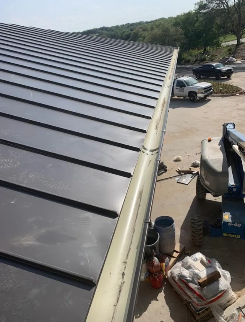 Standing seam panel and gutter detail on a metal roofing jobsite in East Lake-Orient Park